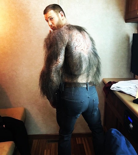 A picture of Tom Hopper wearing his muscle suit.